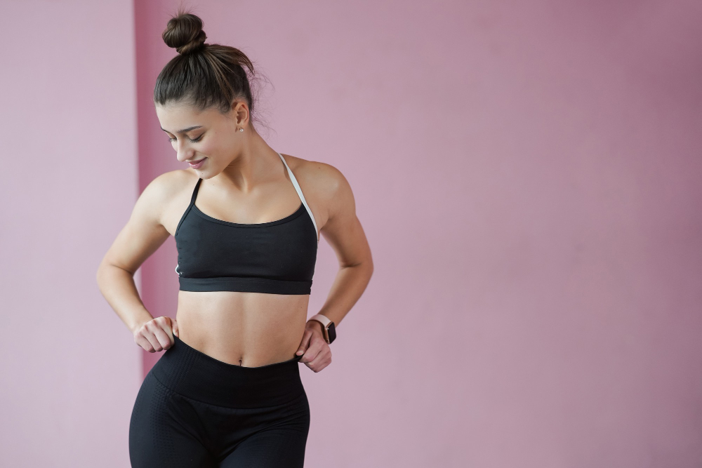 Woman in fitness wear checking her slimmer waistline